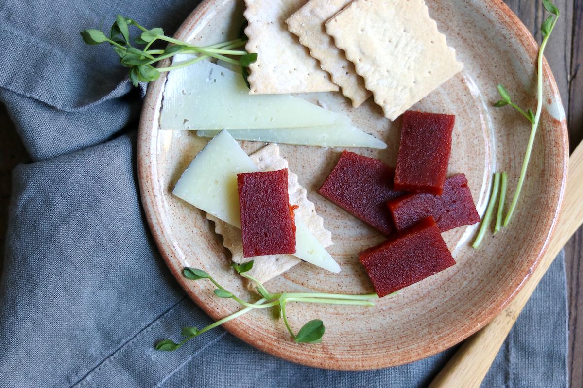 slices of quince paste next to a quince fruit