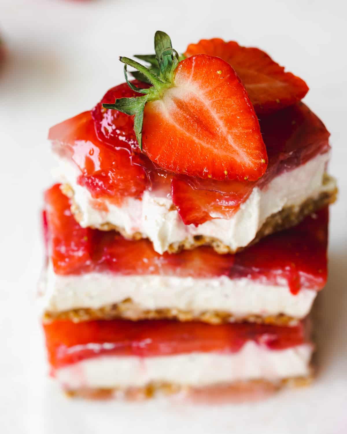 Strawberry Cheesecake Bars being arranged on a serving platter.