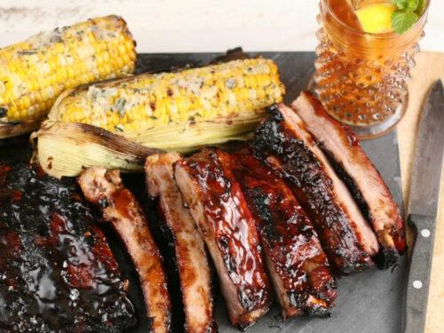family enjoying orange-rosemary bbq ribs at an outdoor barbecue