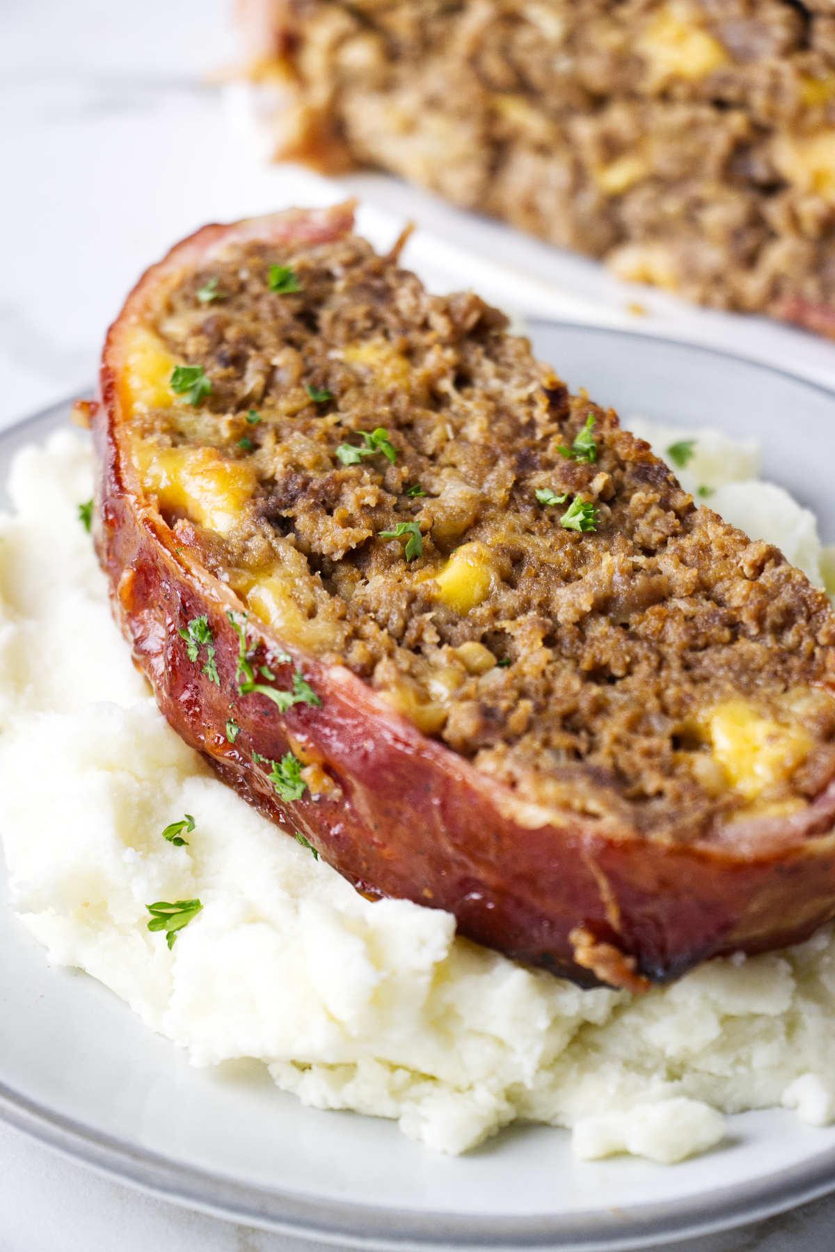 close-up shot of a bacon-wrapped meatloaf being sliced