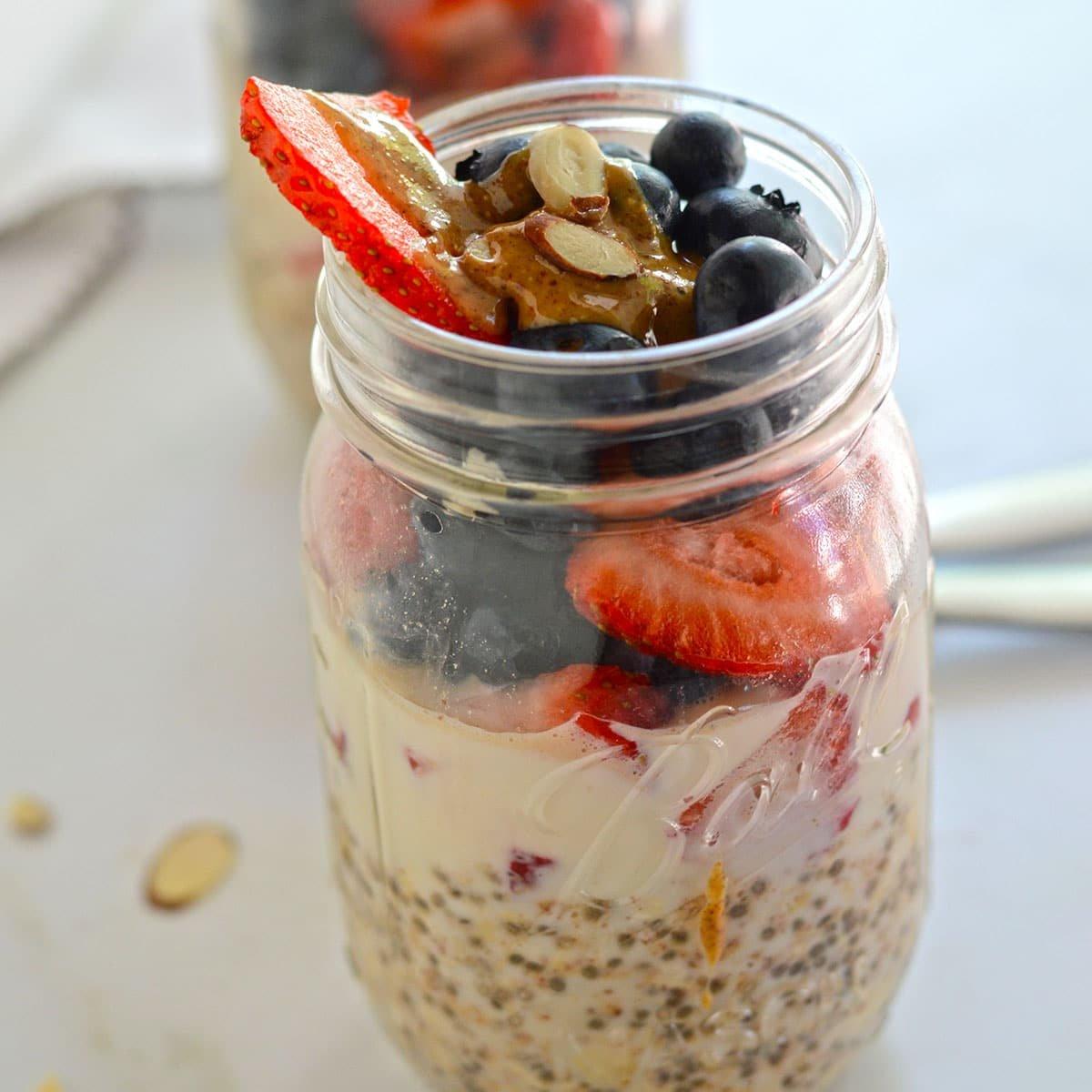 close-up shot of summer berry swirl overnight oats in a clear mason jar