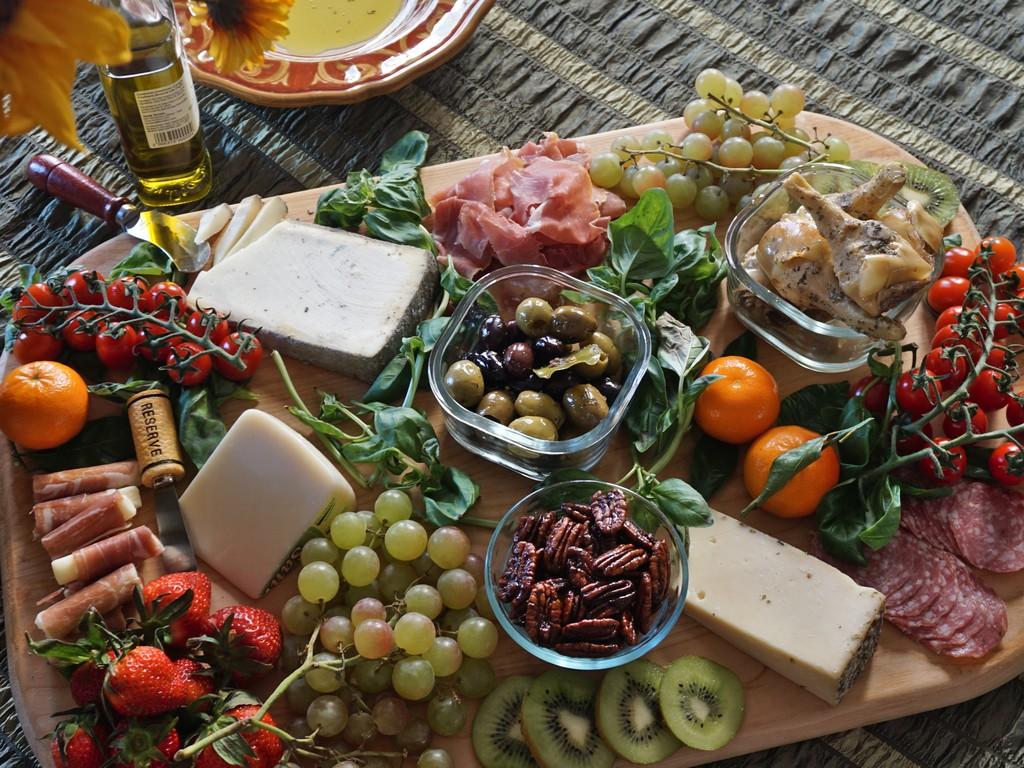 Close-up of an Italian cheese board featuring a variety of cheeses, salami slices, and marinated artichoke hearts