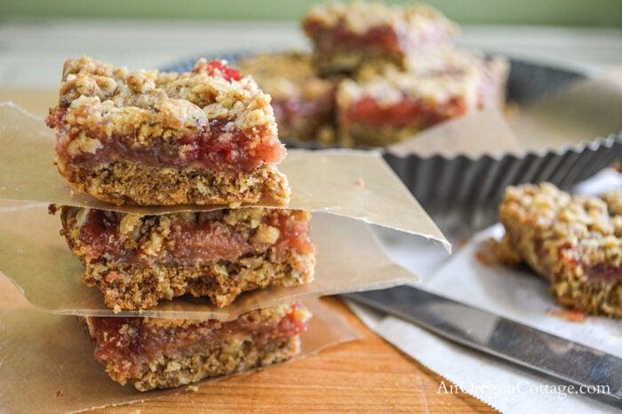Honey Rhubarb Bars with Walnut Topping on a wooden cutting board