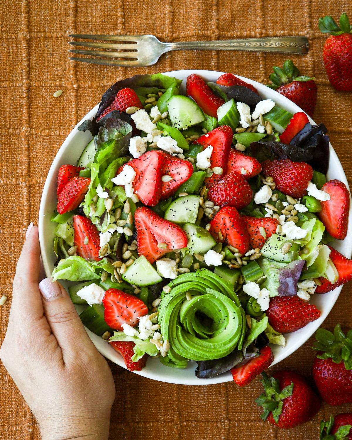 Close-up of a bowl of strawberry feta salad with coriander, showcasing the vibrant colors and textures