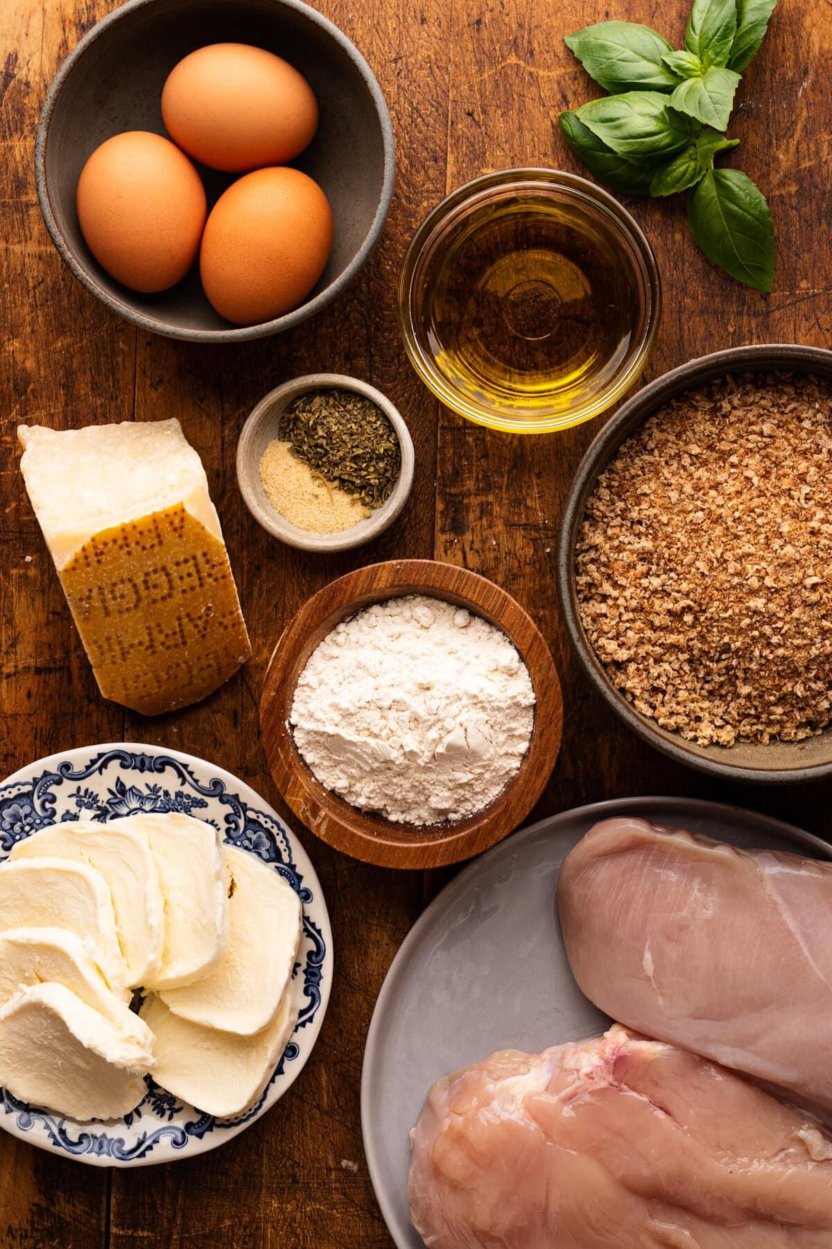 ingredients for chicken parmesan croquettes laid out on a wooden surface
