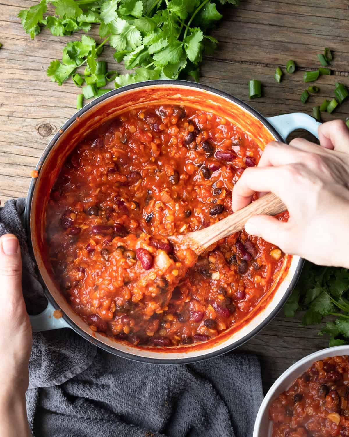steaming pot of vegan chili on a wooden table