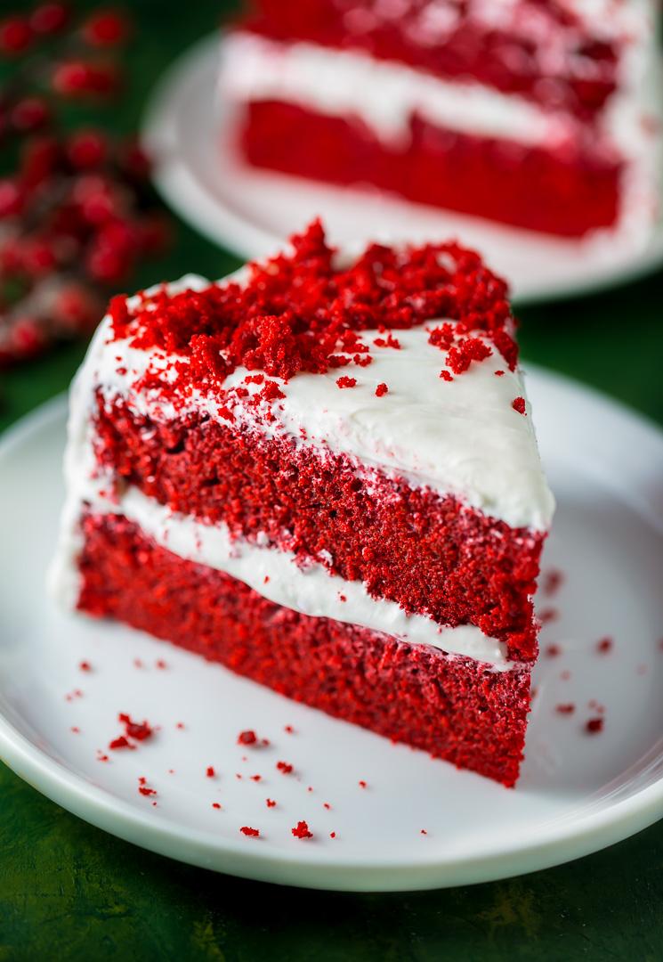 baker frosting a red velvet cake