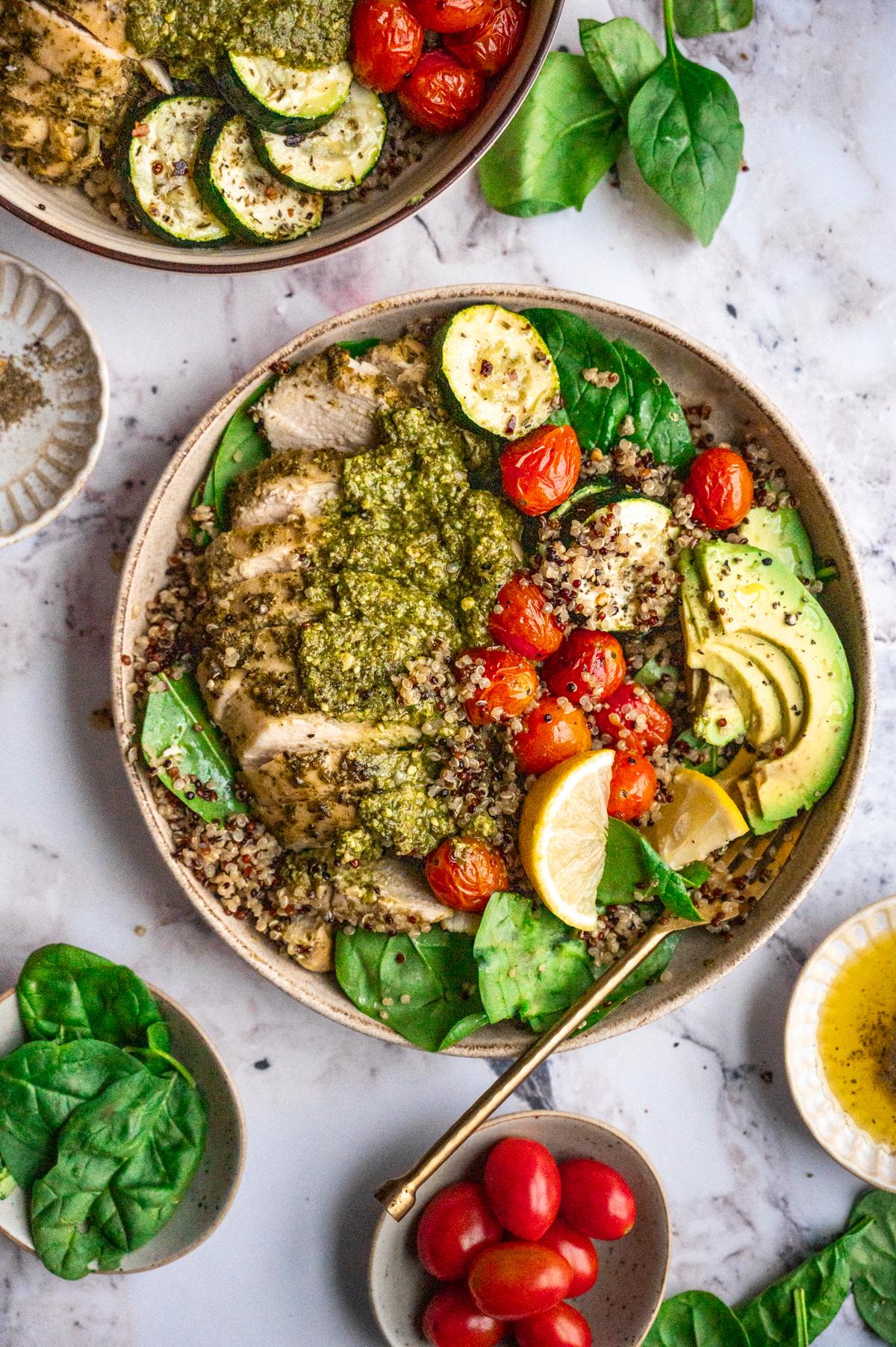 Overhead shot of a vibrant pesto chicken protein bowl, showcasing the colorful ingredients and textures