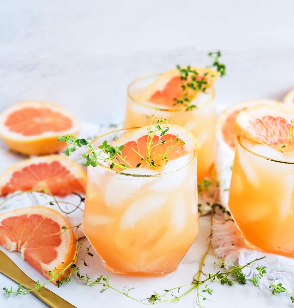 Close-up overhead shot of a perfectly baked Grapefruit & Thyme Tart with Honey Glaze, showcasing the glistening grapefruit slices and thyme sprigs
