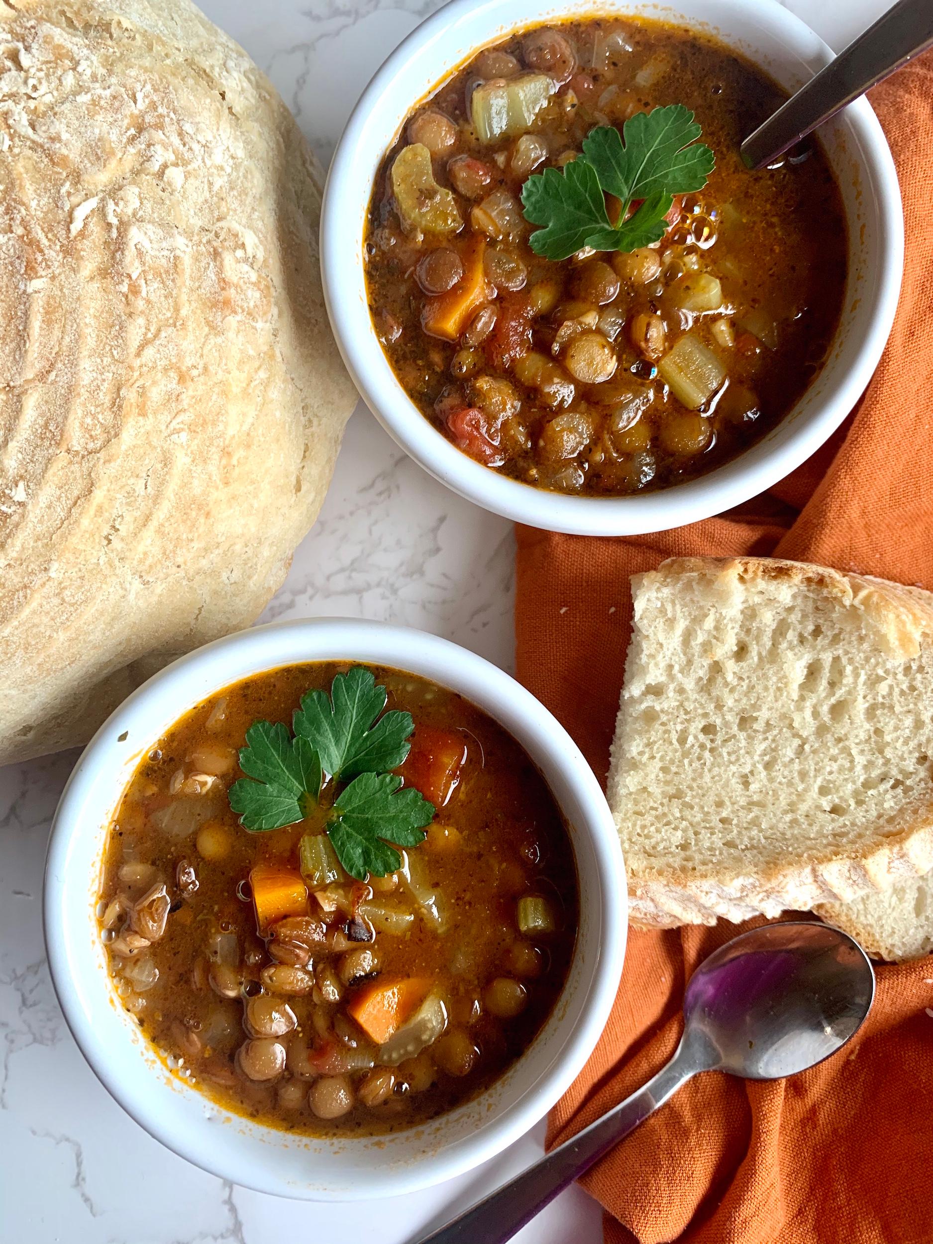 bowl of hearty lentil soup with crusty bread and butter