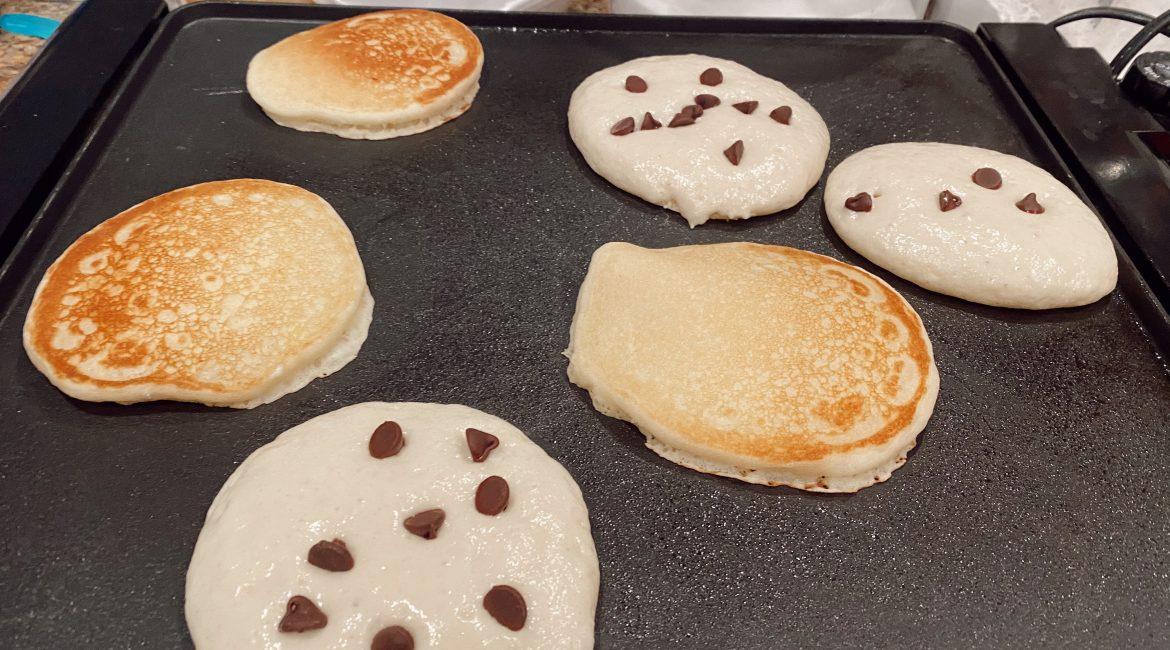 aerial view of chocolate chip gluten-free pancakes cooking on a griddle