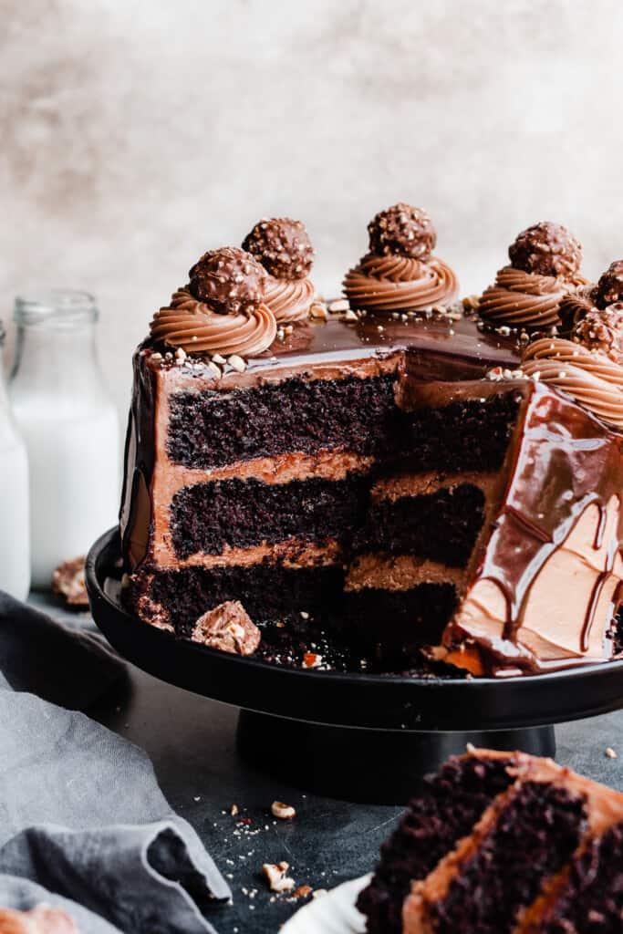 A baked three-layer nutella cake sitting on a cake stand