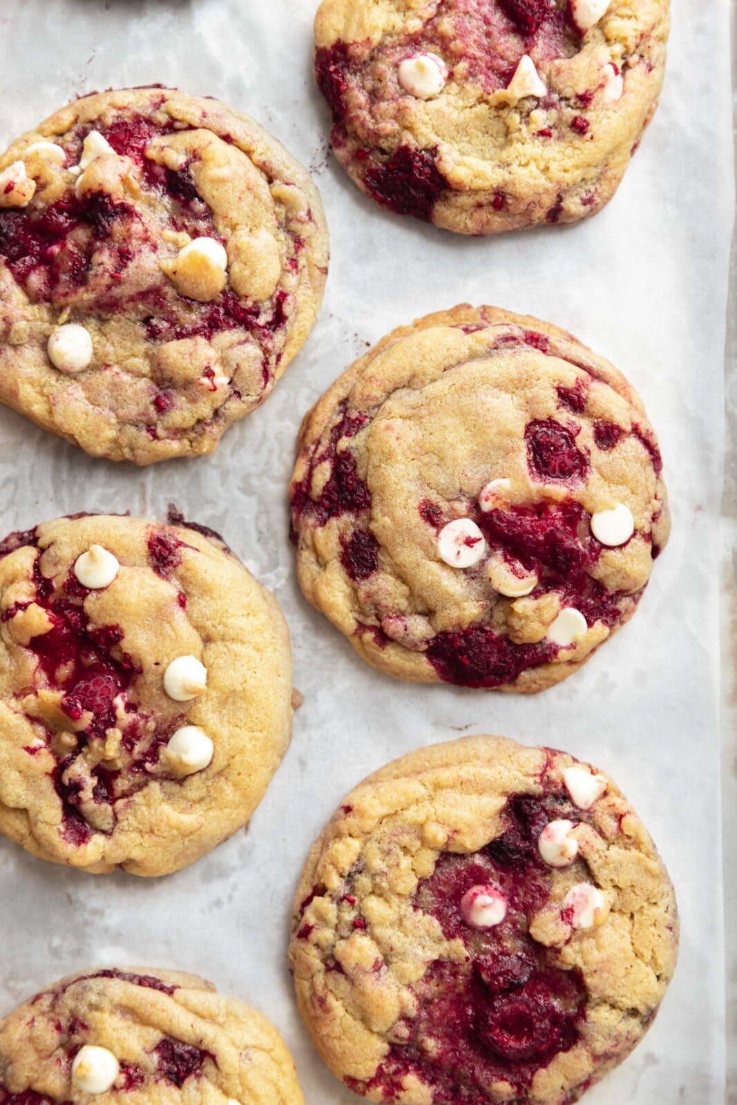 raspberry cookies with white chocolate chips on baking sheet
