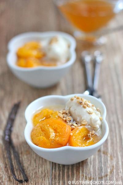 Close-up shot of a glass of apricot vanilla cold brew with ice, garnished with an apricot slice and a vanilla bean