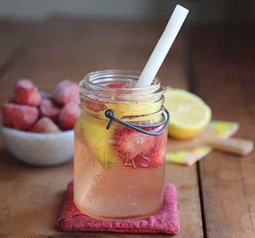 Person spraying strawberry lemonade air freshener in a sunlit kitchen