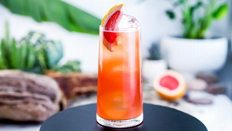Close-up of an Earl Grey Grapefruit Hugo cocktail being poured into a highball glass