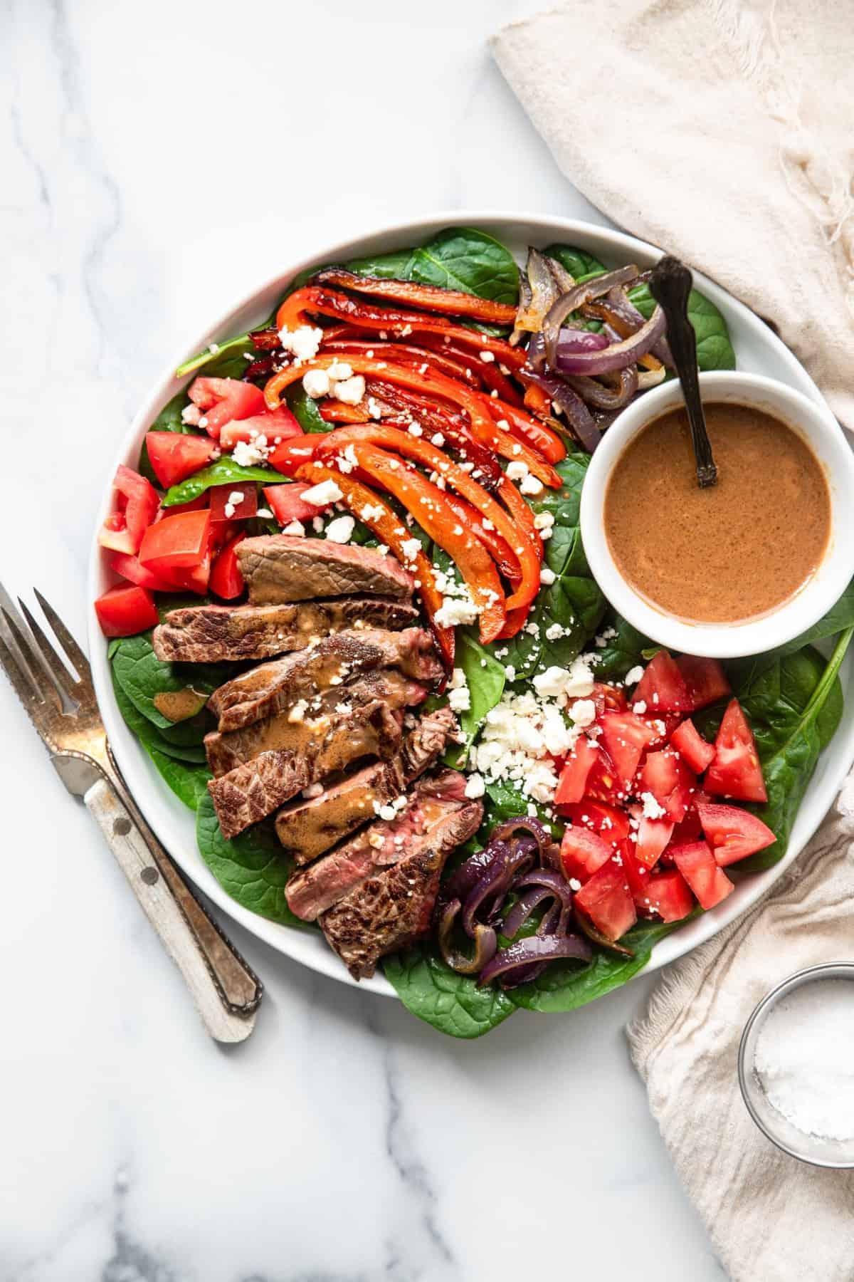 Father's Day steak salad with balsamic glazed onions on a wooden table