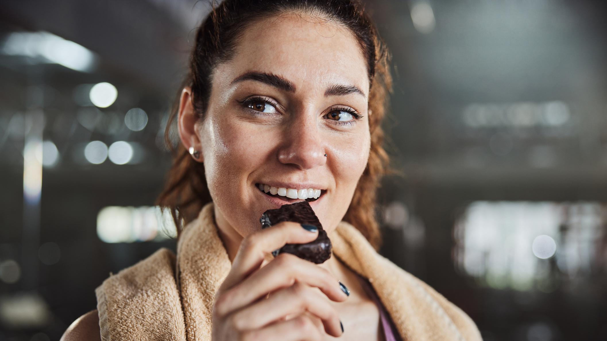 a person happily biting into a salted caramel protein bar, close-up shot
