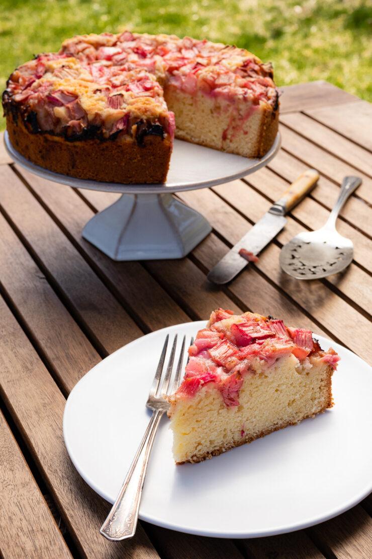 rustic rhubarb cake with powdered sugar on a wooden table