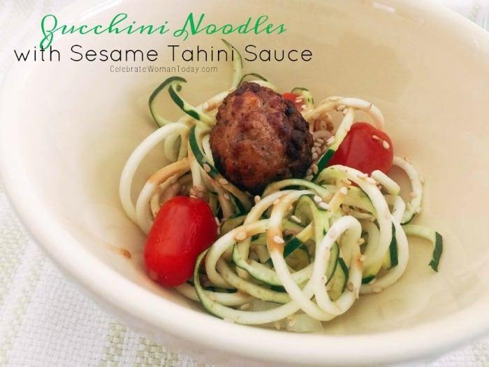 zucchini noodles being tossed with sesame tahini dressing