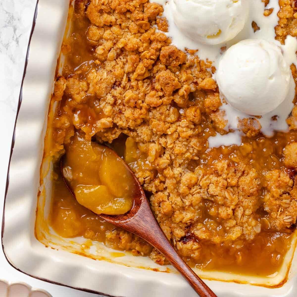 Ingredients for apple peach ginger crisp arranged on a wooden table