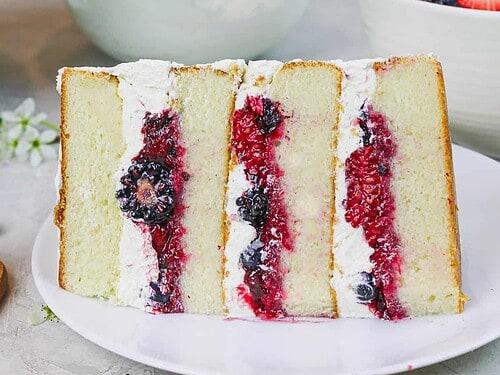 close-up shot of a slice of vanilla birthday cake with goji berry compote