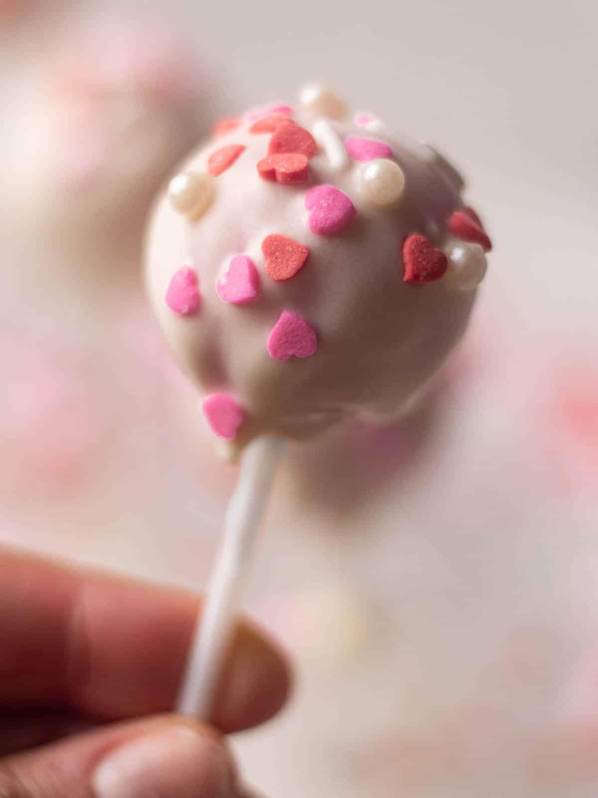 close up of a heart shaped cake pop with sprinkles
