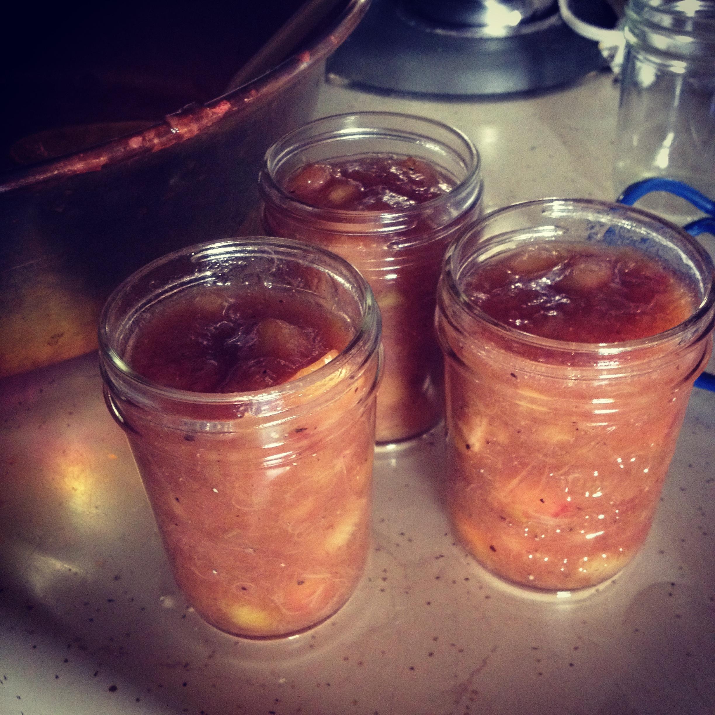 Close-up of a jar of Rose Geranium Rhubarb Compote with fresh rose geranium leaves