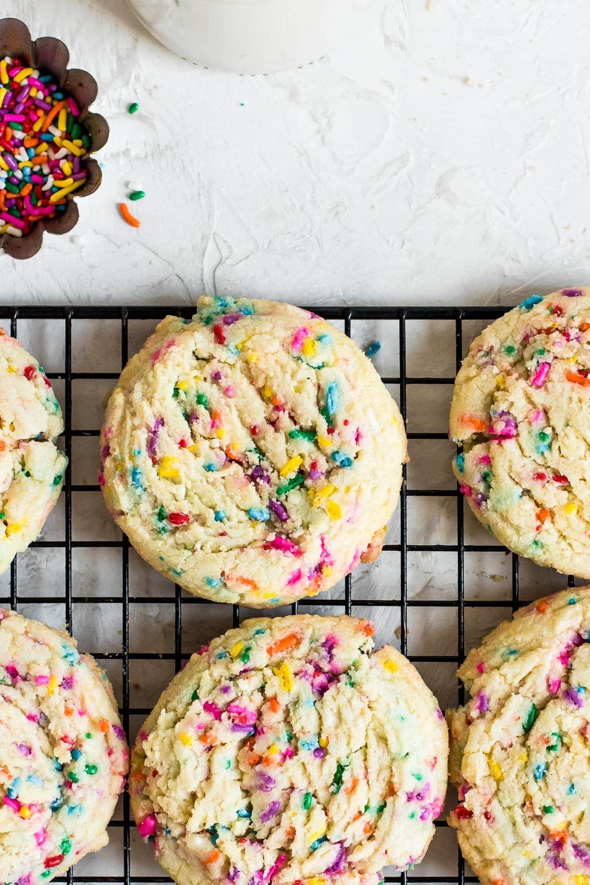 close-up shot of baked science-themed sugar cookies on a cooling rack, with colorful sprinkles