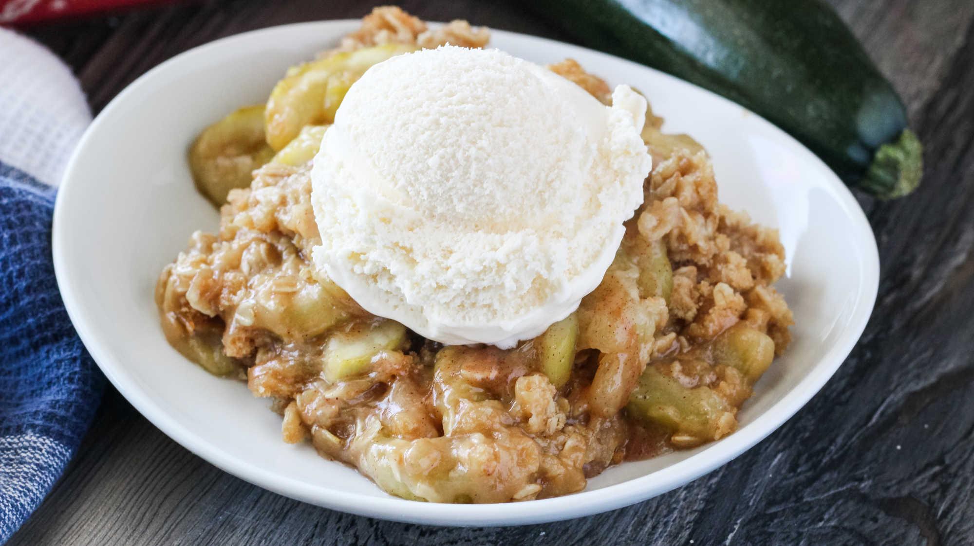 Slice of zucchini crumble bake being served with vanilla ice cream