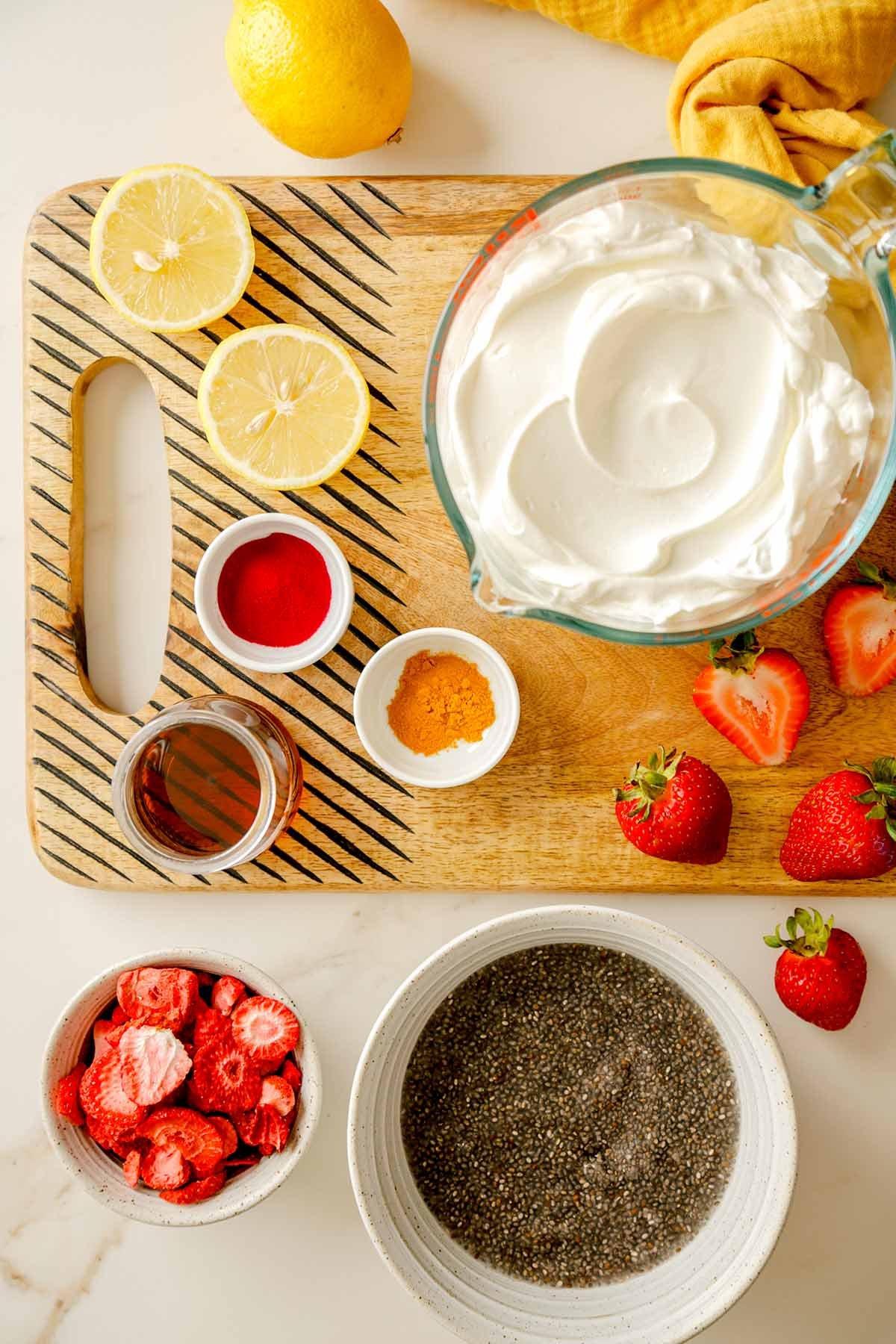 overhead view of ingredients for strawberry lemonade chia pudding arranged on a wooden surface