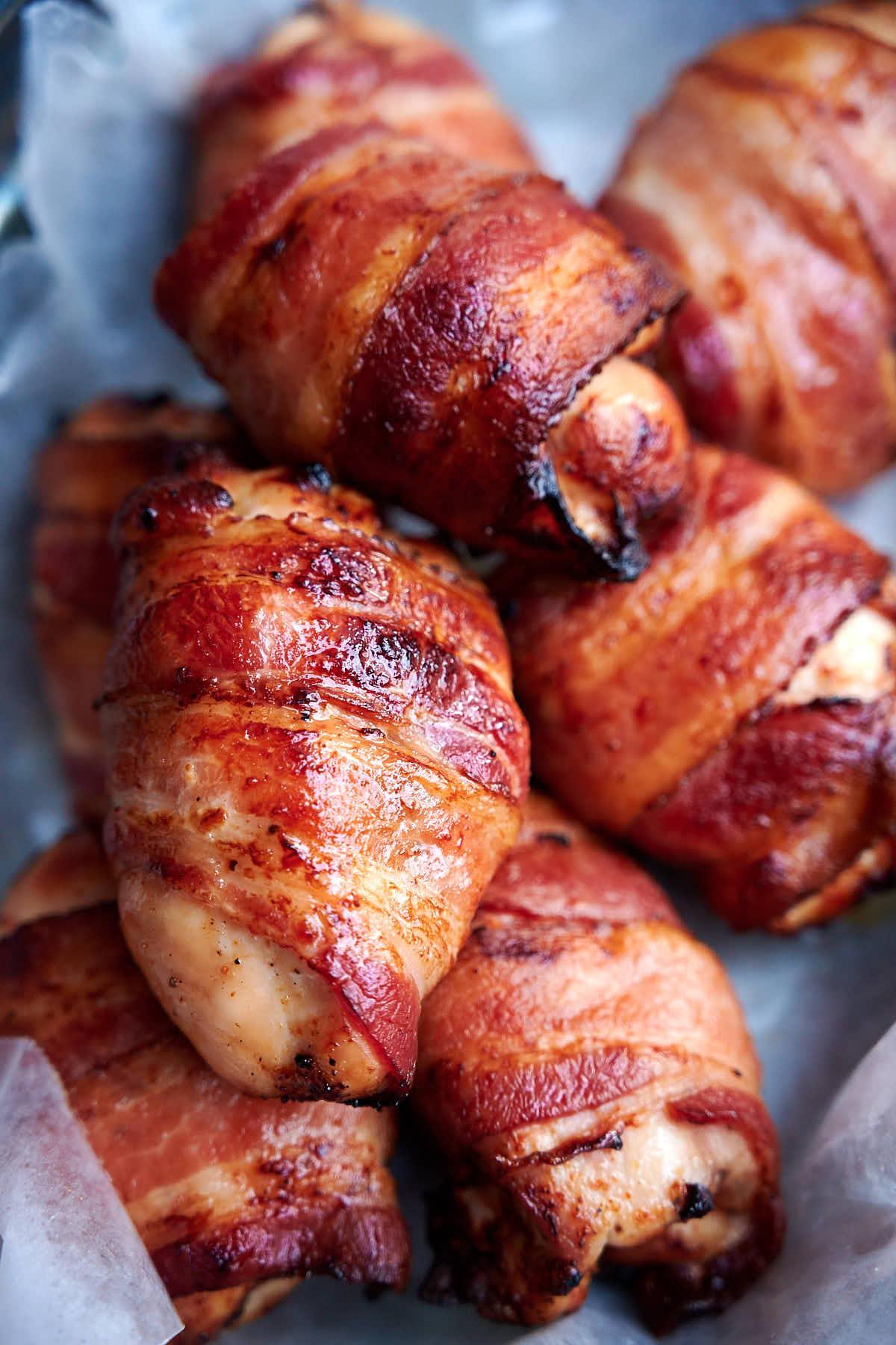 a close-up shot of crispy bacon wrapped around a juicy chicken thigh