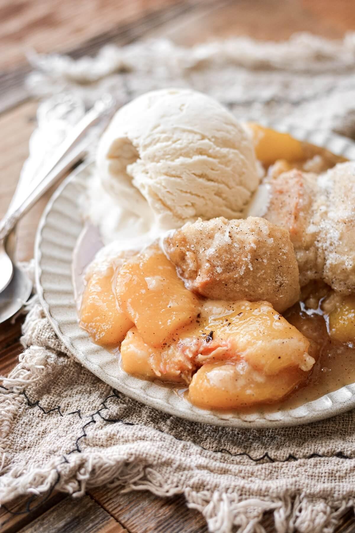 close up shot of bourbon peach cobbler with cinnamon swirl showing the bubbly filling and golden crust