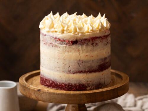 A fully assembled Scarlet Velvet Kiss Layer Cake on a cake stand
