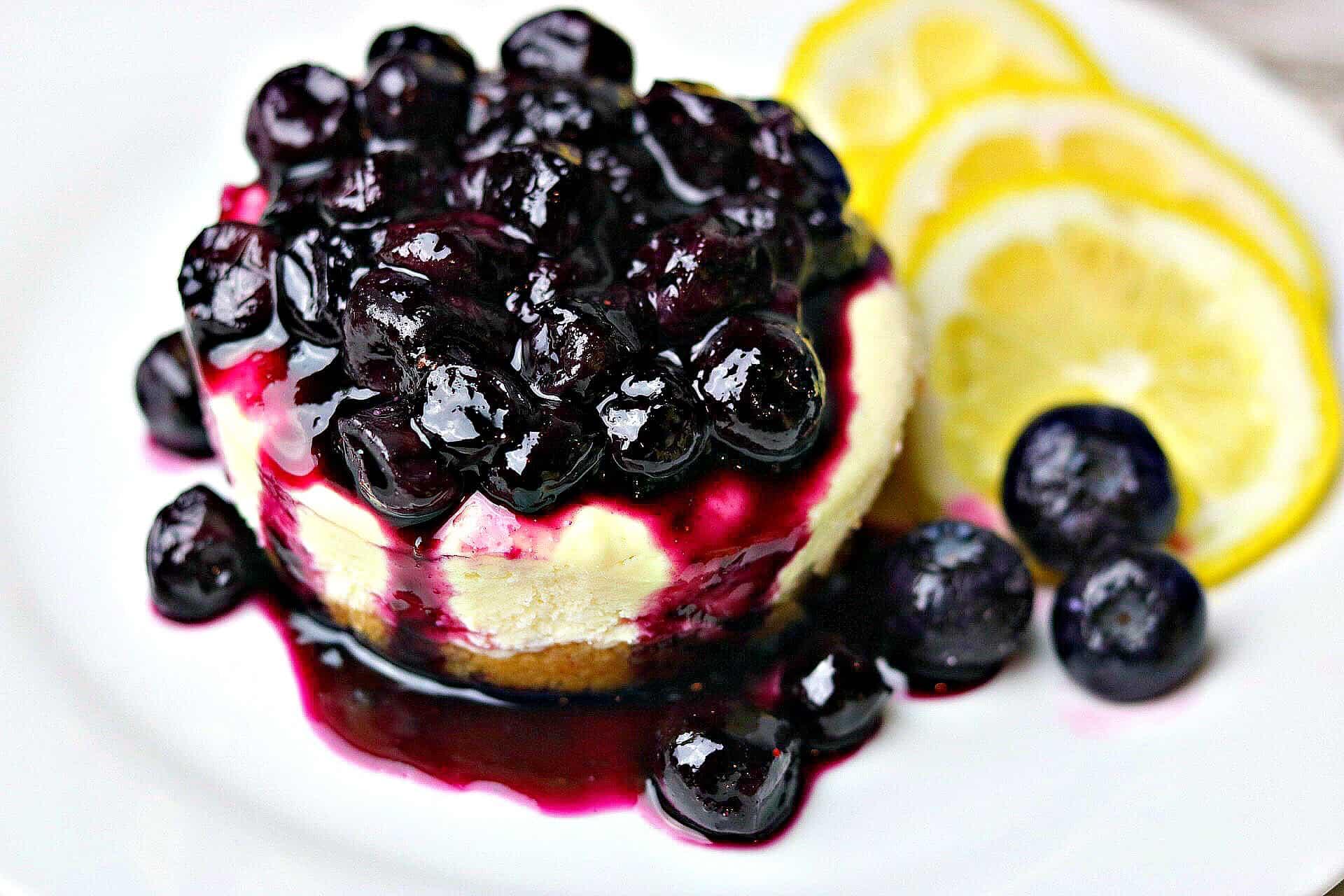 A plate of low carb blueberry cheesecake bites with some scattered blueberries