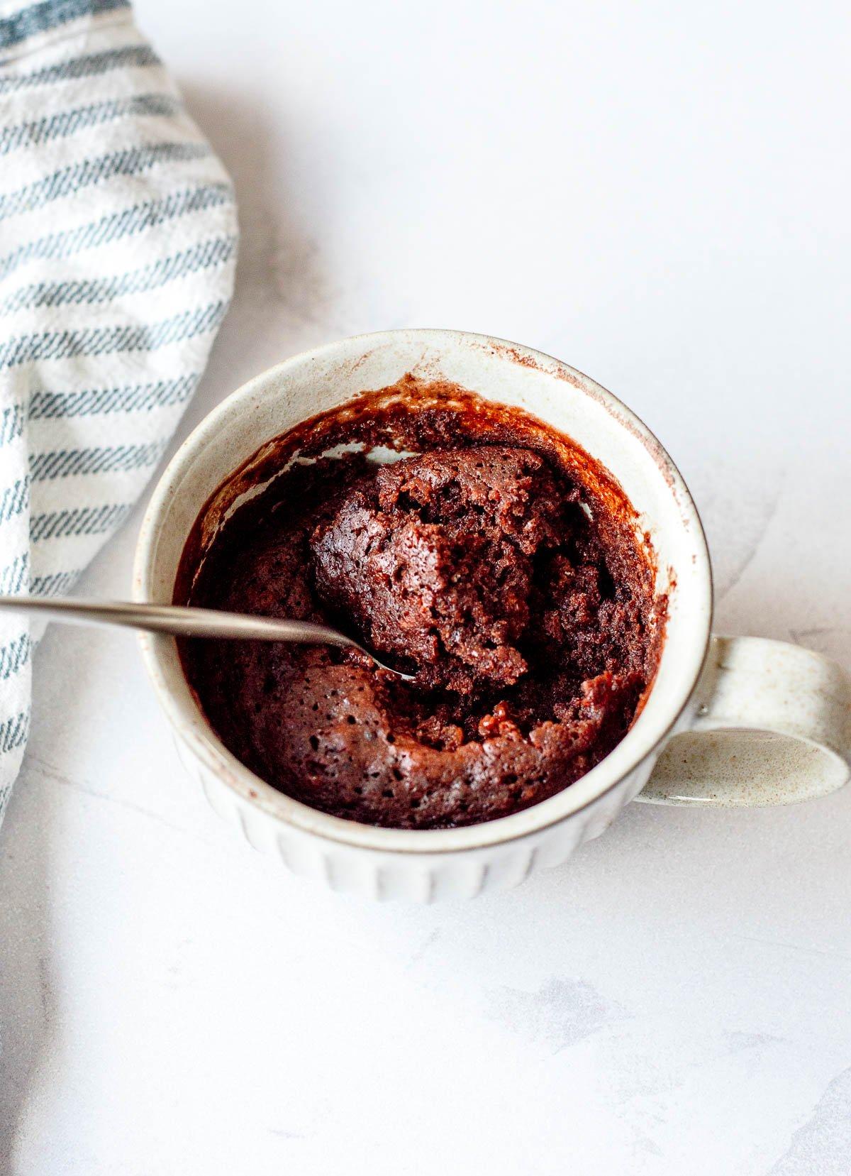 close up of a spoon scooping into a dark chocolate cayenne pepper mug cake