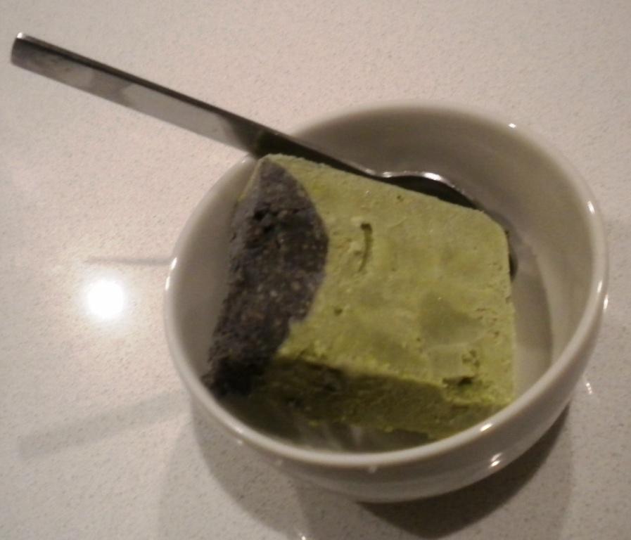 Swirling black sesame and matcha ice cream bases together in a container