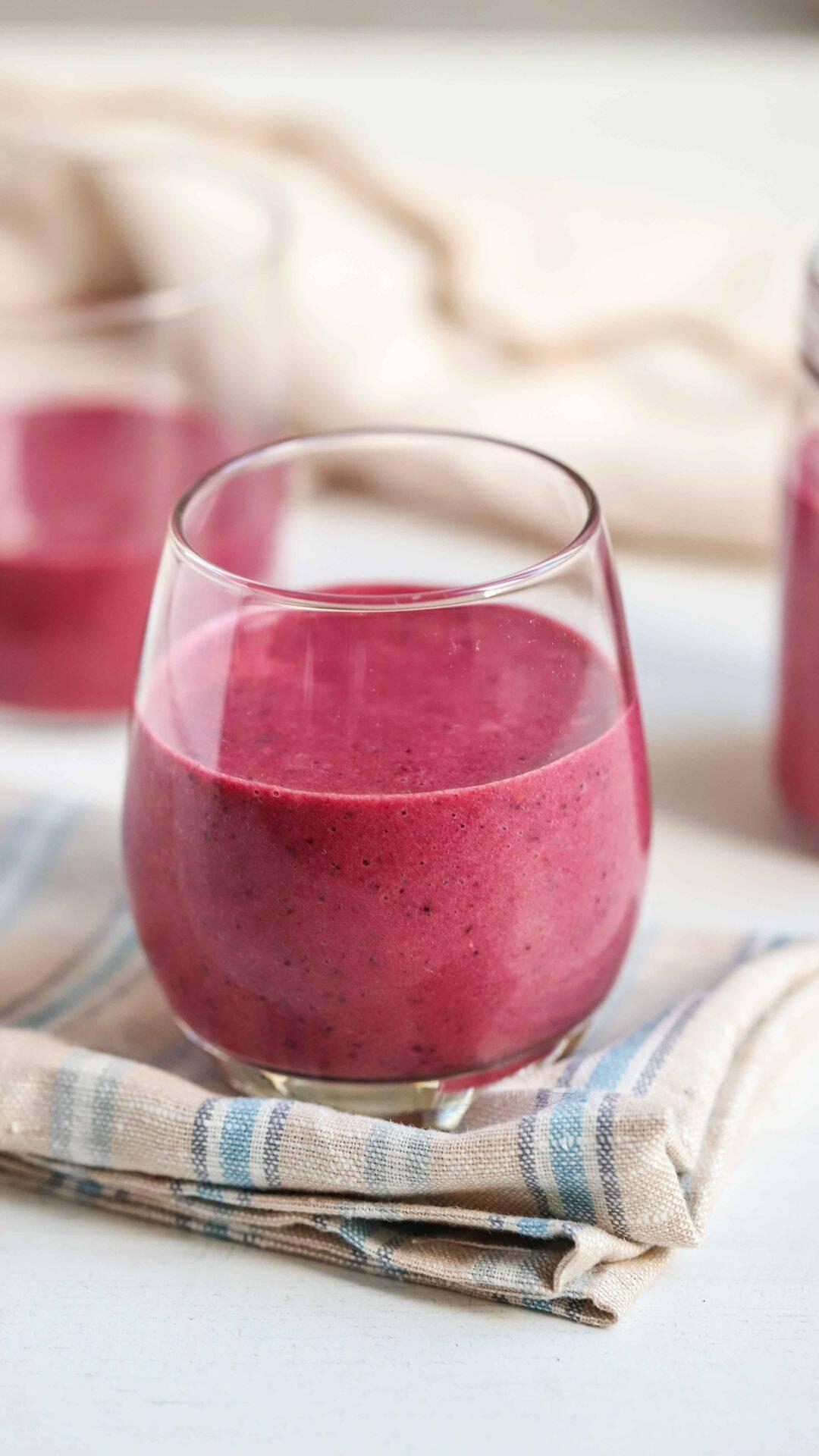 bright red raspberry beet ginger protein smoothie in glass