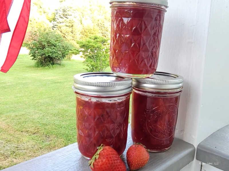 jars of homemade strawberry lemonade preserves on a wooden table