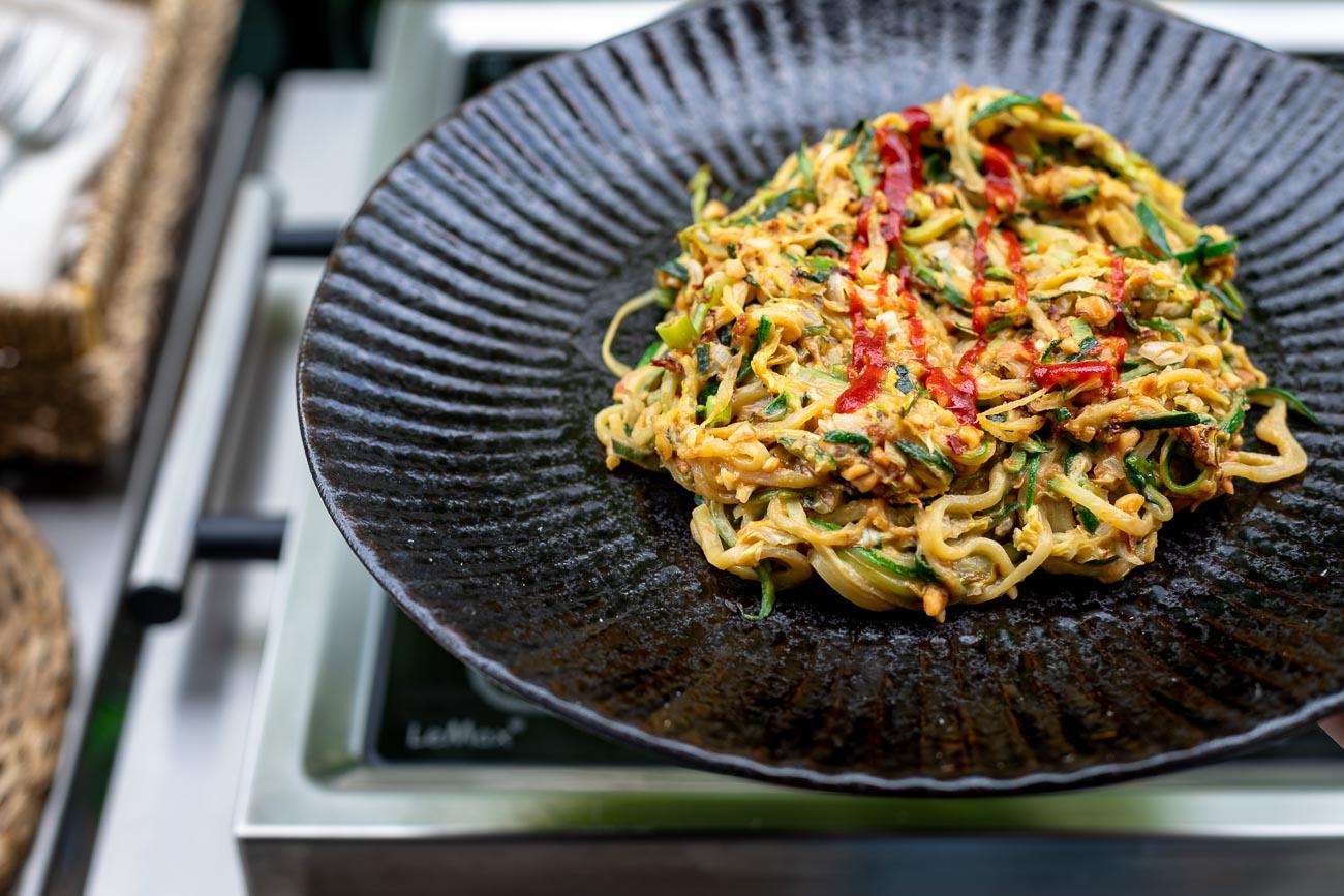Ingredients for Mediterranean zoodle stir-fry laid out on a wooden table