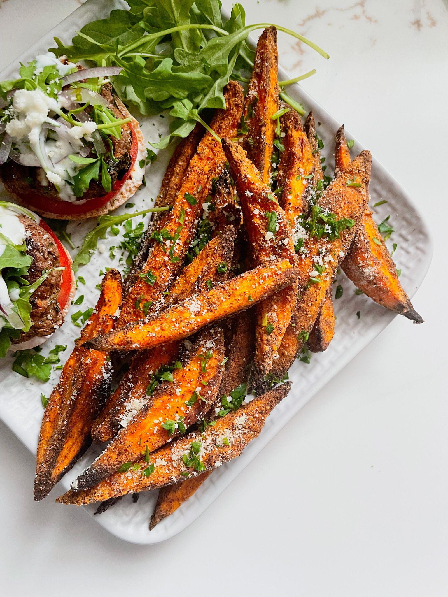 a close-up shot of sweet potato fries drizzled with massaman curry sauce
