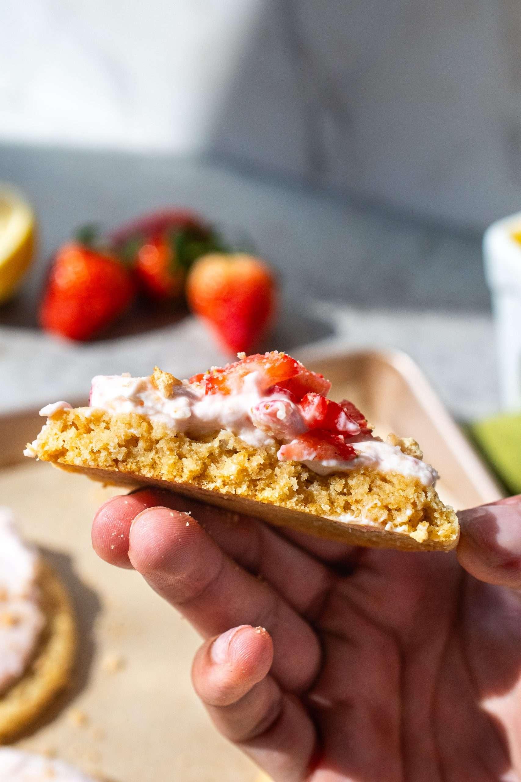 hands arranging strawberry slices on the cheesecake filling