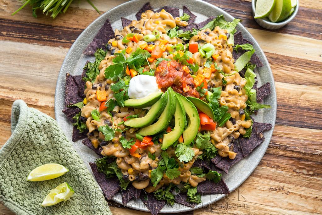 bowl of creamy guacamole mac and cheese topped with fresh cilantro and tortilla chips