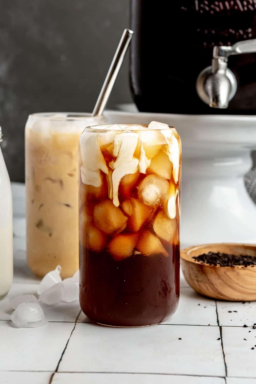 Close-up shot of a glass bottle filled with cold brew coffee, with vanilla beans next to it.