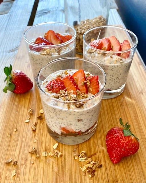 A child helping to assemble a Strawberry Oatmeal Yogurt Parfait