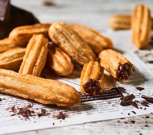 freshly fried milk chocolate hazelnut churros on a wire rack