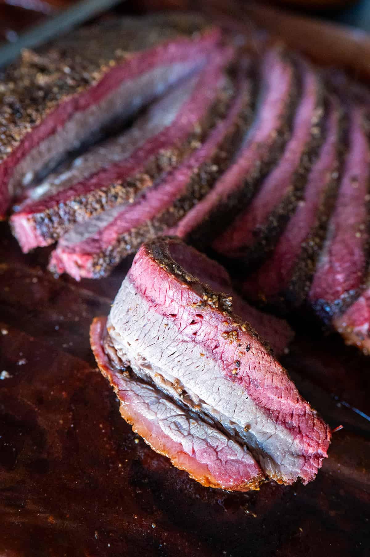 close-up shot of sliced smoked brisket showing the smoke ring