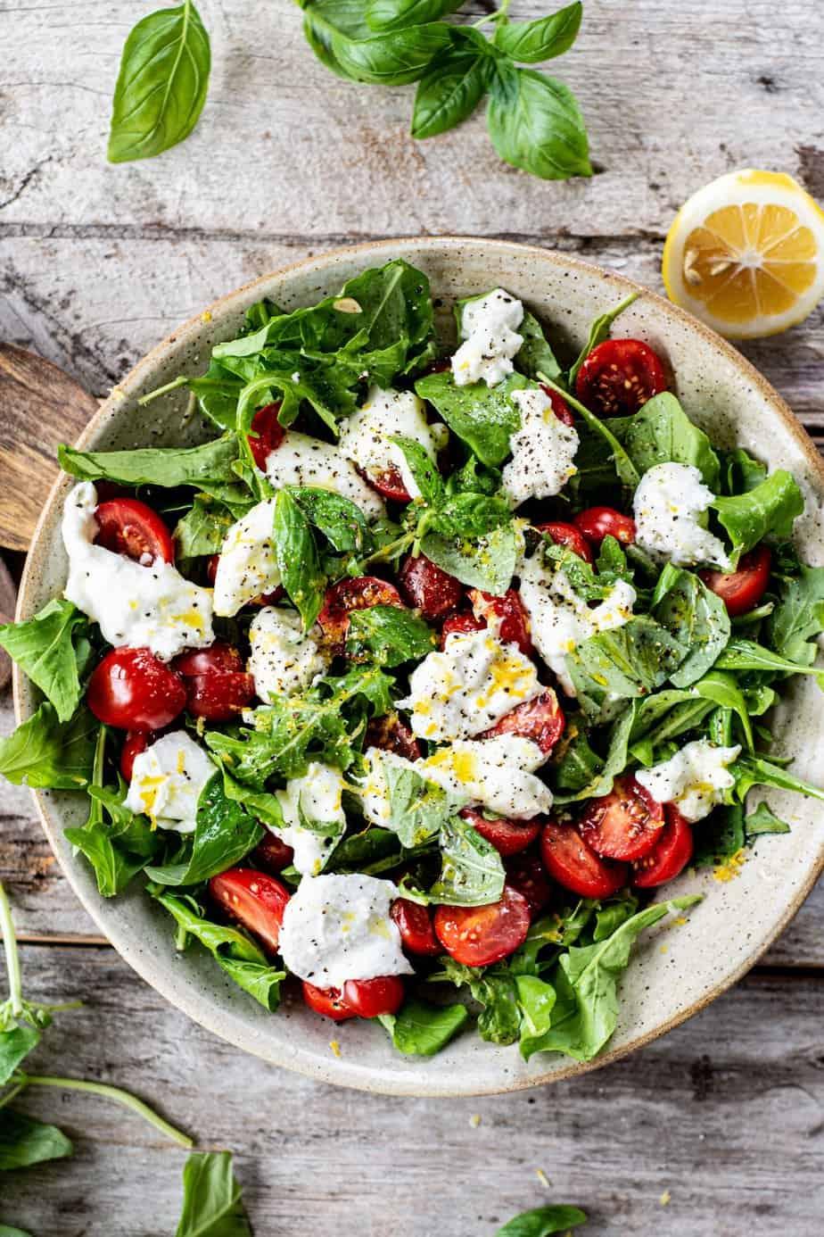Caprese salad with arugula on a white platter