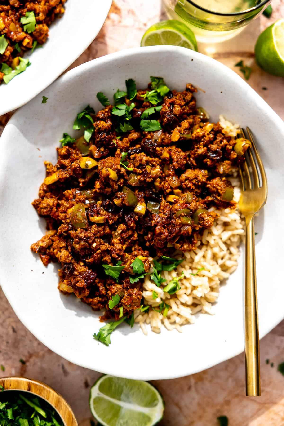 A vibrant bowl of Cuban picadillo with rice, showcasing the textures of ground beef, olives, and raisins