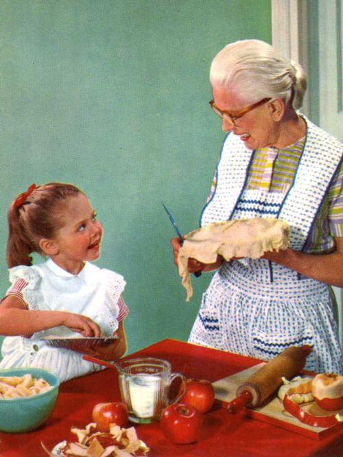 grandmother and child in kitchen with baking apples